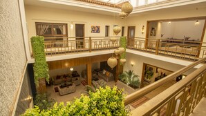 A multi-level hotel lobby with a glass ceiling, a central seating area, and a staircase. - Riad Azia: Serenity in Marrakech Your Oasis Awaits! 🌺 (Marrakech)