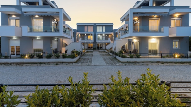 Un bâtiment moderne à la structure symétrique, doté de nombreux balcons et d’une entrée centrale.