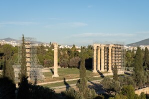 A historical site with ancient columns and a building under construction. - Acropolis Elegant Penthouse (Athens)