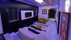Una sala de estar moderna con una televisión de pantalla plana, un sofá, una mesa de centro y una alfombra estampada.