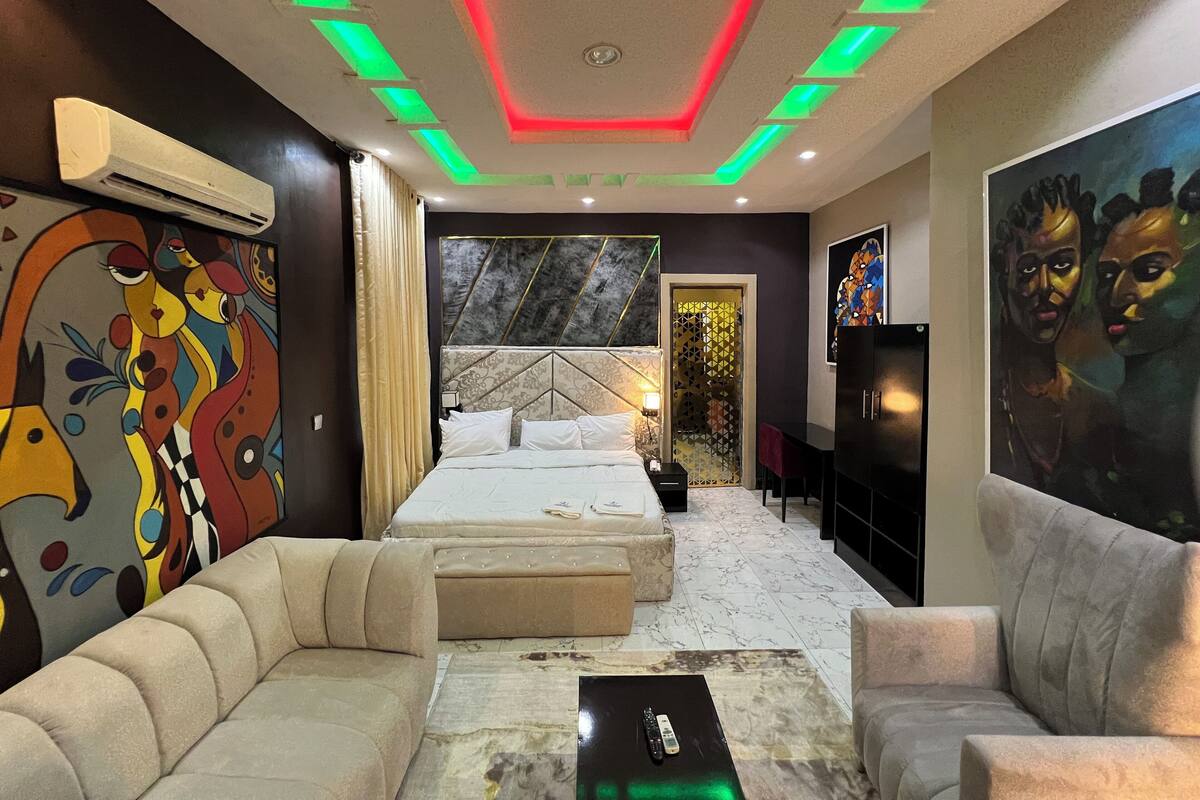 Un dormitorio moderno con una cama grande, un sofá y un televisor.