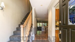 A staircase with wooden railings leading to a dining area with a view of greenery outside. - Near golf course with summer pool (GR14) (Incline Village)