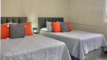 Habitación de hotel con dos camas, una ventana y una lámpara en el techo.
