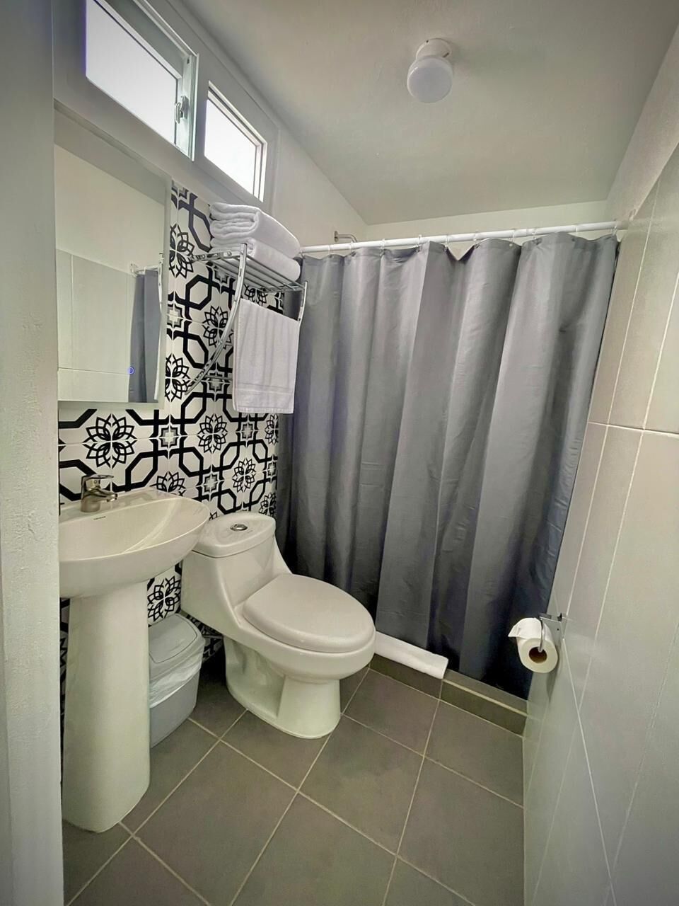 A bathroom with a toilet, sink, and shower curtain.