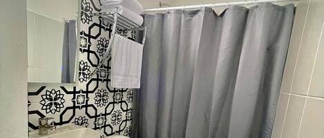 A bathroom with a toilet, sink, and shower curtain.