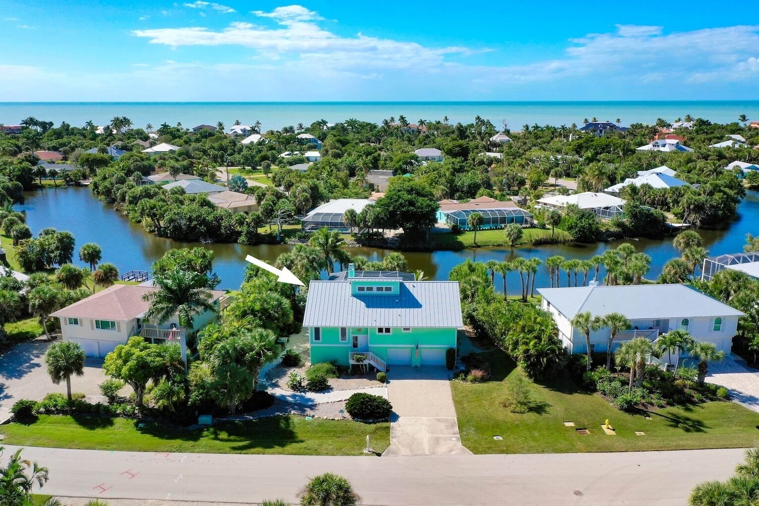 A coastal residential area with houses surrounded by water and greenery.