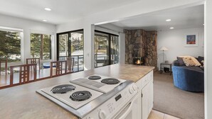 A modern kitchen with a large island, a stone fireplace, and a view of the outdoors. - Walk to the Dillon Amphitheater, Marina and more! (Dillon)