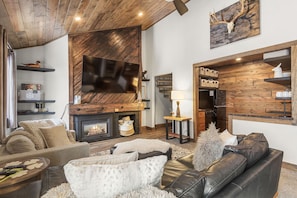 A cozy living room with a fireplace, leather sofa, and wooden decor.