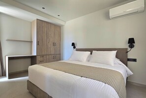 A bedroom with a bed, a wardrobe, a desk, and a wall-mounted air conditioner. - Trapezia Luxury Living - Opal (Afantou)
