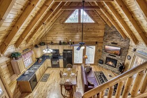 Una cabaña acogedora con cocina, comedor y chimenea.