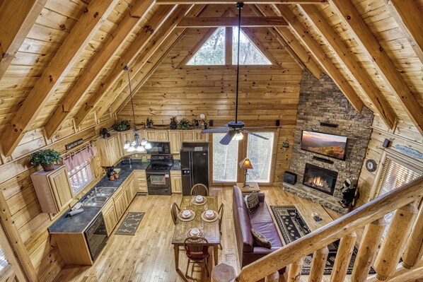 Una cabaña acogedora con cocina, comedor y chimenea.