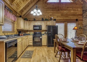 Cocina de cabaña de madera con microondas, refrigerador y horno integrados.
