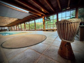 Amplio espacio interior con piscina, ventanas grandes y un instrumento de percusión.