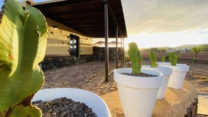 Un edificio con fachada de piedra y un patio cubierto.