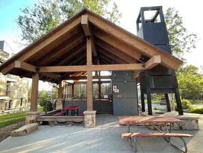 A covered pavilion with picnic tables and a large electrical box.