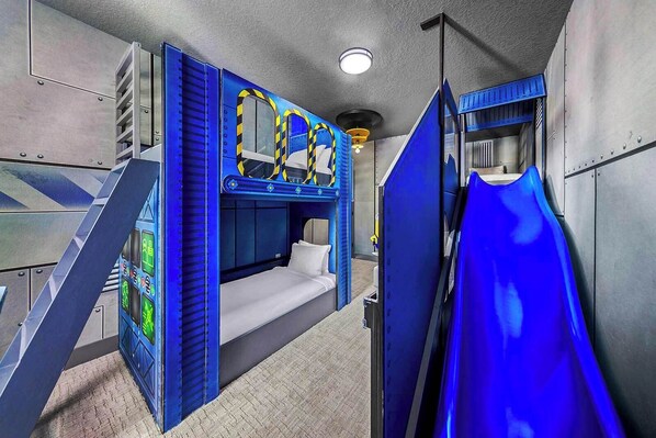 A bunk bed room with a slide, a control panel, and a ceiling light. - Casper's Courtyard | Fab home w science lab themed room, PVT pool - near airport (Orlando)
