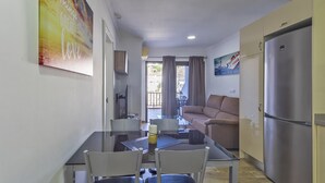 A compact living space with a kitchenette, a dining area, and a sofa.