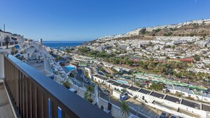 A coastal town with a view of the sea, a swimming pool, and a variety of buildings.