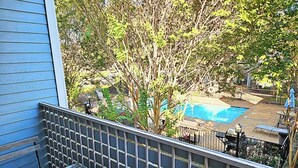 A residential backyard with a swimming pool, a wooden deck, and a metal fence. - I30 - Apt|Patio|11mi to Convention Ctr|Sleeps 2 (Irving)