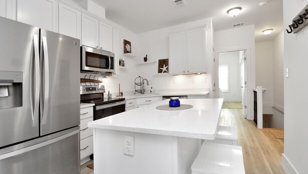 A modern kitchen with white cabinetry, stainless steel appliances, and a central island. - "Dock, Relax, and Unwind at Waterside Retreat!" (Mexico Beach)