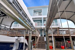 A multi-level deck with wooden railings, a staircase, and various equipment. - "Dock, Relax, and Unwind at Waterside Retreat!" (Mexico Beach)