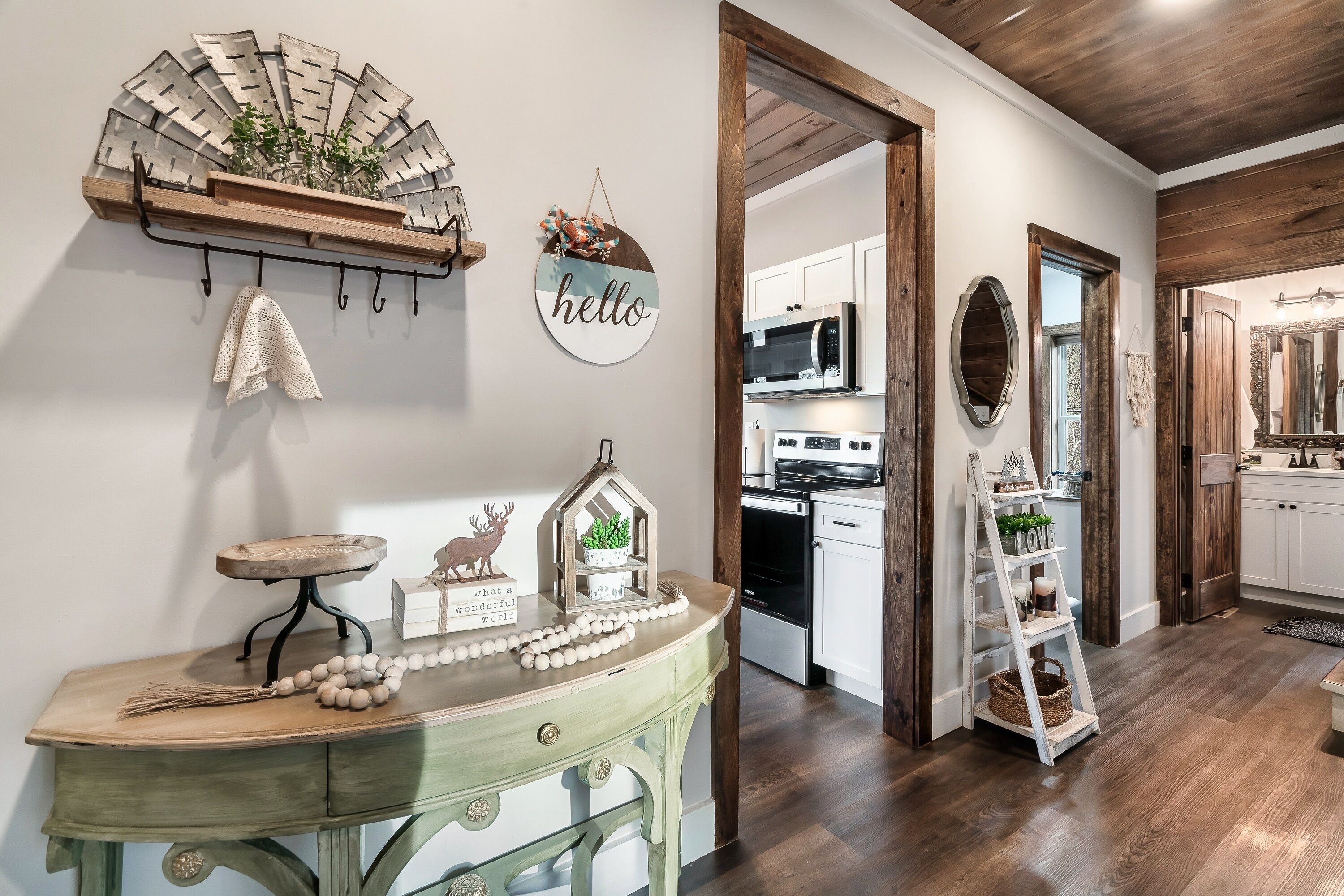 A kitchen with white cabinets, a microwave, and a wooden ceiling.