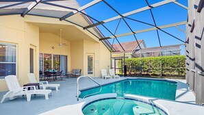 A covered outdoor swimming pool with lounge chairs and a hot tub. - The Hideaway@Tuscan Hills, a modern 4 bedroom, 3 bath luxury home (Davenport)