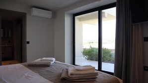 Ein Hotelzimmer mit Bett, Fenster mit Blick und einer Klimaanlage.
