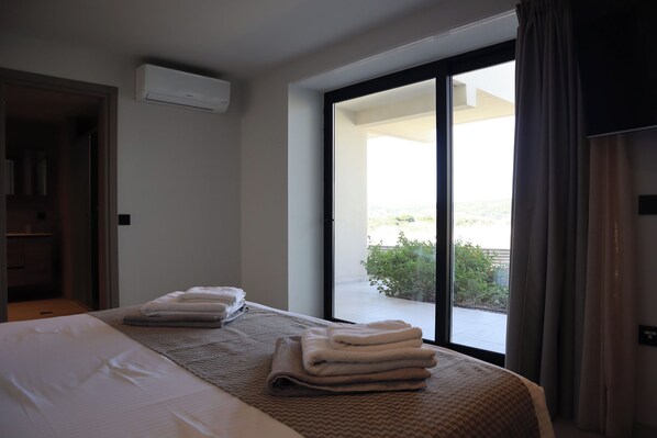 Ein Hotelzimmer mit Bett, Fenster mit Blick und einer Klimaanlage.