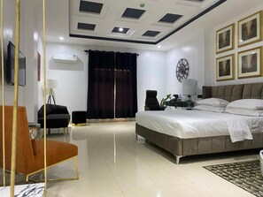 Un dormitorio moderno con una cama grande, un escritorio, una silla y un televisor.