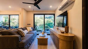 Una sala moderna con un sofá, una mesa de centro y vistas a zonas verdes.