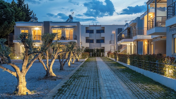 A modern hotel with a central courtyard, multiple balconies, and a well-maintained garden. - Antigone Residential Complex (Pangaio)