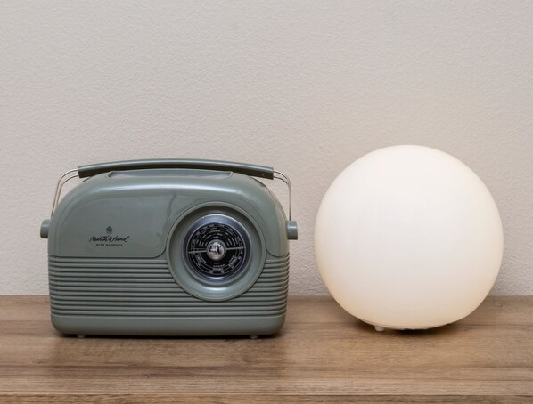 A vintage radio and a spherical light on a wooden surface.