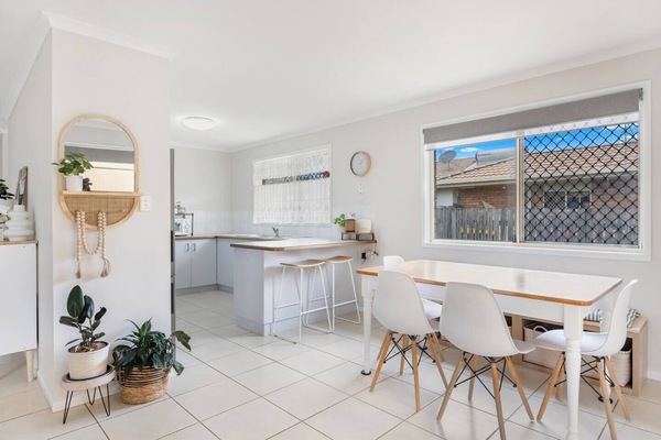 The bright dining area features a table setting, ideal for meals at home and can also serve as a dedicated workspace.