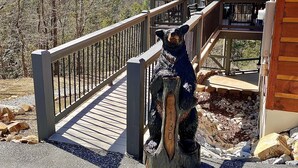 A wooden deck with a railing leading to a covered area with a view of mountains. - One-of-kind Views! Stunning Sunsets! Highly Sought after Location! (Marion)