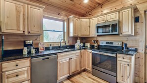 Una cocina moderna con armarios de madera, electrodomésticos de acero inoxidable y un amplio ventanal.