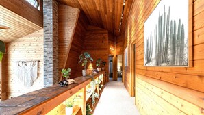 A wooden interior with a long hallway, wooden benches, and potted plants. - Rapids Rustic Retreat (Wisconsin Rapids)