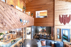 A spacious loft-style interior with a kitchen, dining area, and seating space.