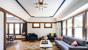 Amplia sala de estar con sofá, mesa de centro y comedor con mesa y sillas.