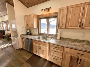 A kitchen with wooden cabinets, a stainless steel sink, and a window with a view. - NEW! LAST MIN SPECIAL! Ski Chalet, Spacious, Clean, Close To Everything! (Big Sky)