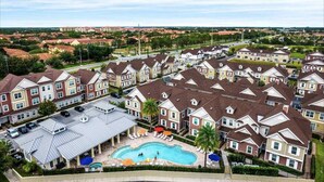 A residential area with multiple two-story houses, a swimming pool, and a parking lot. - 2024 Unique Villa 5 min to Disney (Kissimmee)