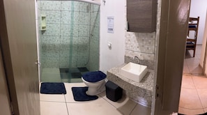A bathroom with a shower, toilet, and sink. - Hostel Jotaaa F (Ourinhos)