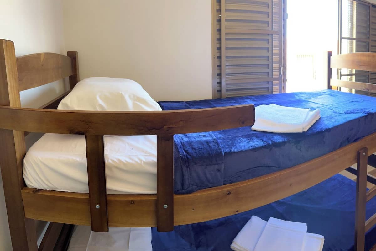 A dormitory room with bunk beds, a small table, and chairs.
