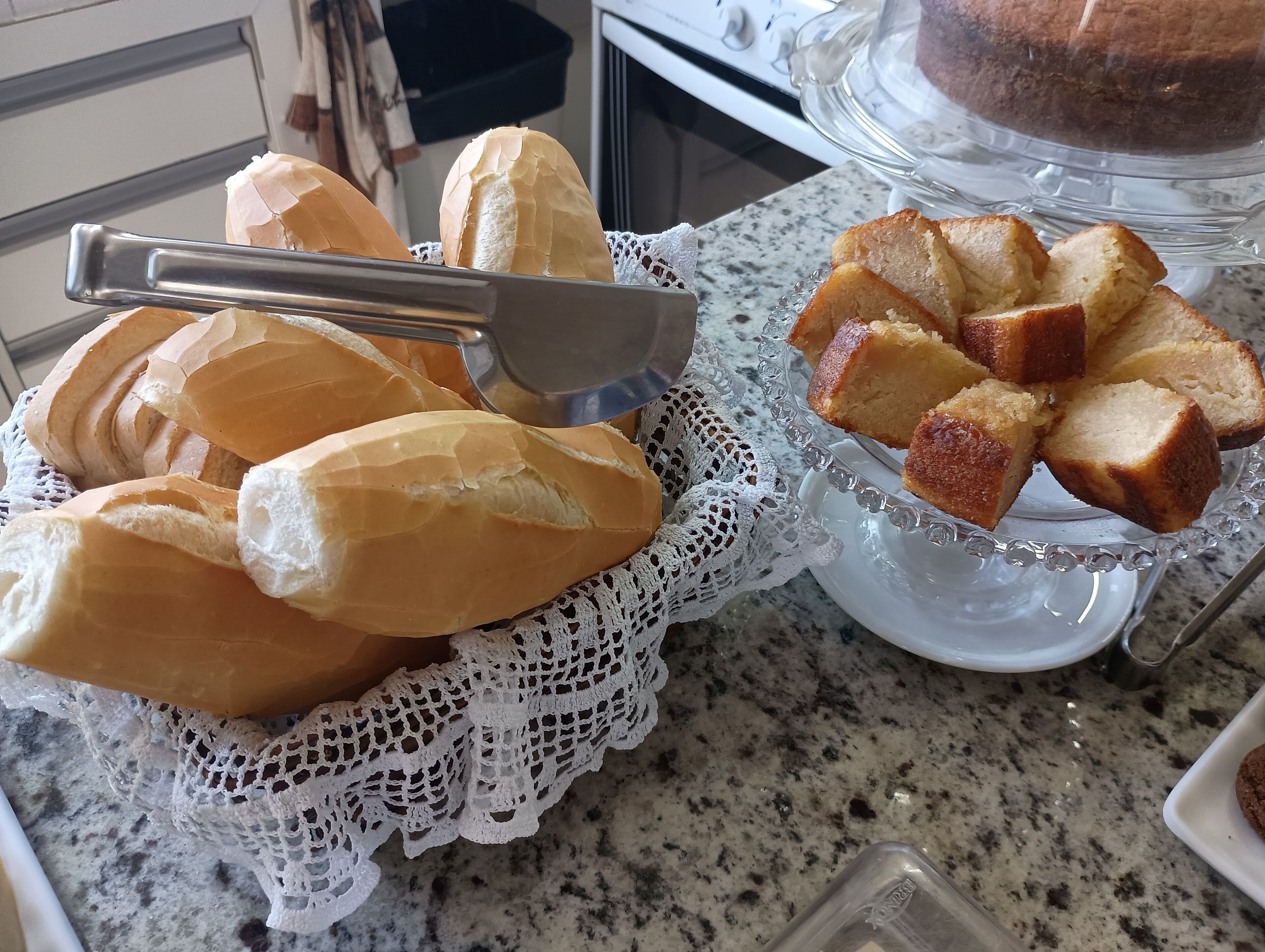 Una encimera de cocina con una hogaza de pan y un plato de rebanadas.