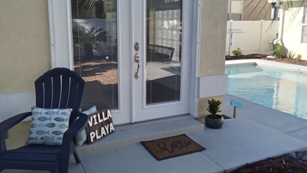 Ein Haus mit Pool, einem Liegestuhl und einem Schild mit der Aufschrift 'Villa Playa'.