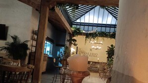 An interior view of a hotel with a high ceiling, wooden beams, and a central chandelier. - Valerio Hotel Boutique  (Marinilla)