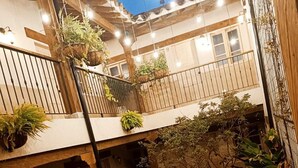 A multi-level courtyard with potted plants, a staircase, and a seating area. - Valerio Hotel Boutique  (Marinilla)