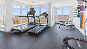 A gym with treadmills, a stationary bike, and a trampoline. - ML390 King Bed Sleeps 8 Quiet Mountain View WiFi (Snowshoe)