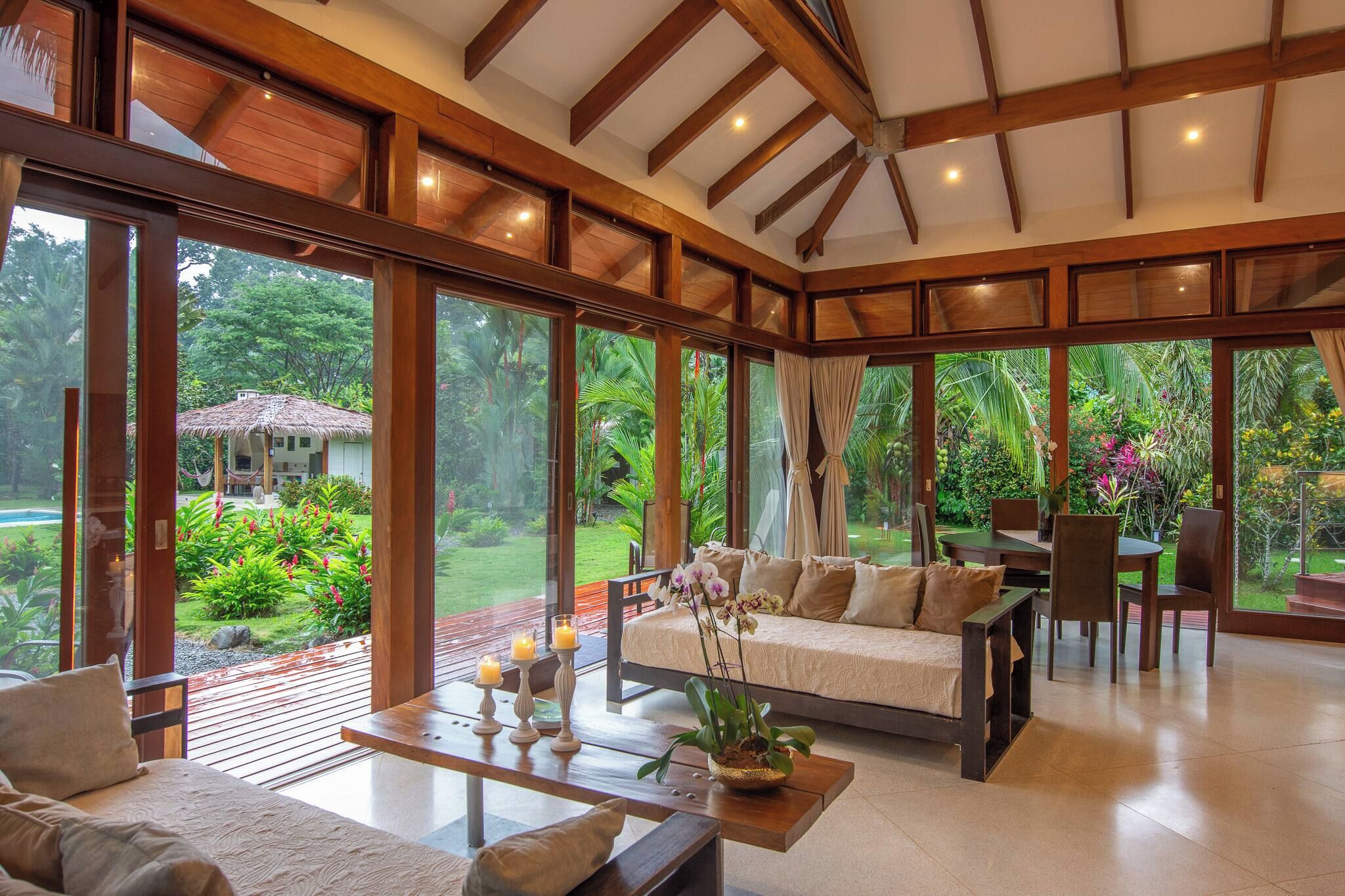 Habitación amplia con una cama grande, zona de comedor y vistas a un jardín exuberante.