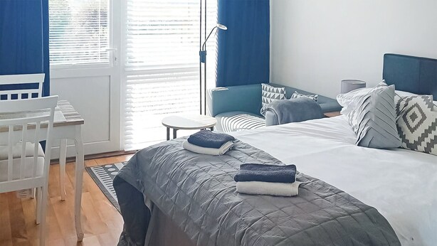 Une chambre à coucher moderne avec un lit, des tables de chevet et une chaise.